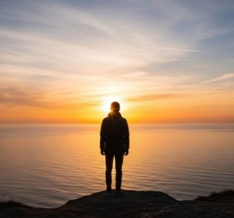 Pessoa olhando o nascer do sol representando o conceito de frase motivacional do dia.