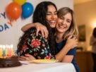 Duas amigas comemorando aniversário com abraço e sorriso sincero.