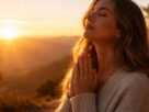 Pessoa em momento de oração ao amanhecer com expressão de fé e paz.